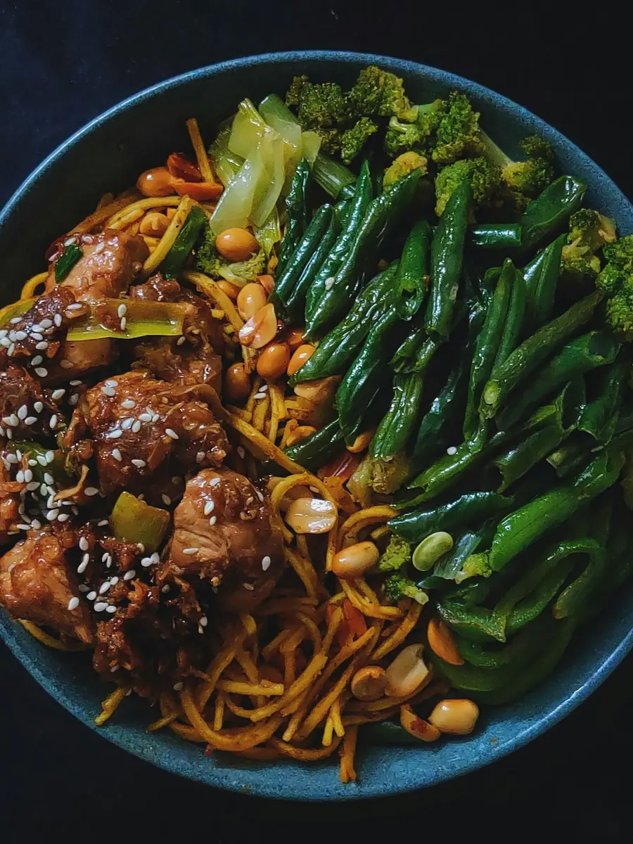 A bowl of glazed chicken with green beans, portioned to macro targets